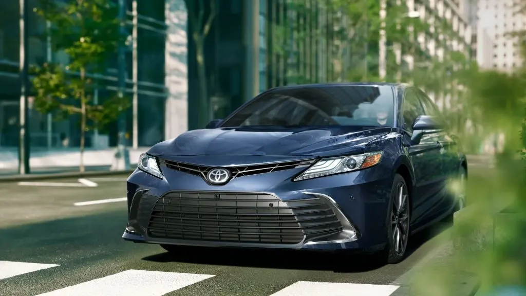 2024 Toyota Camry hybrid driving down the street
