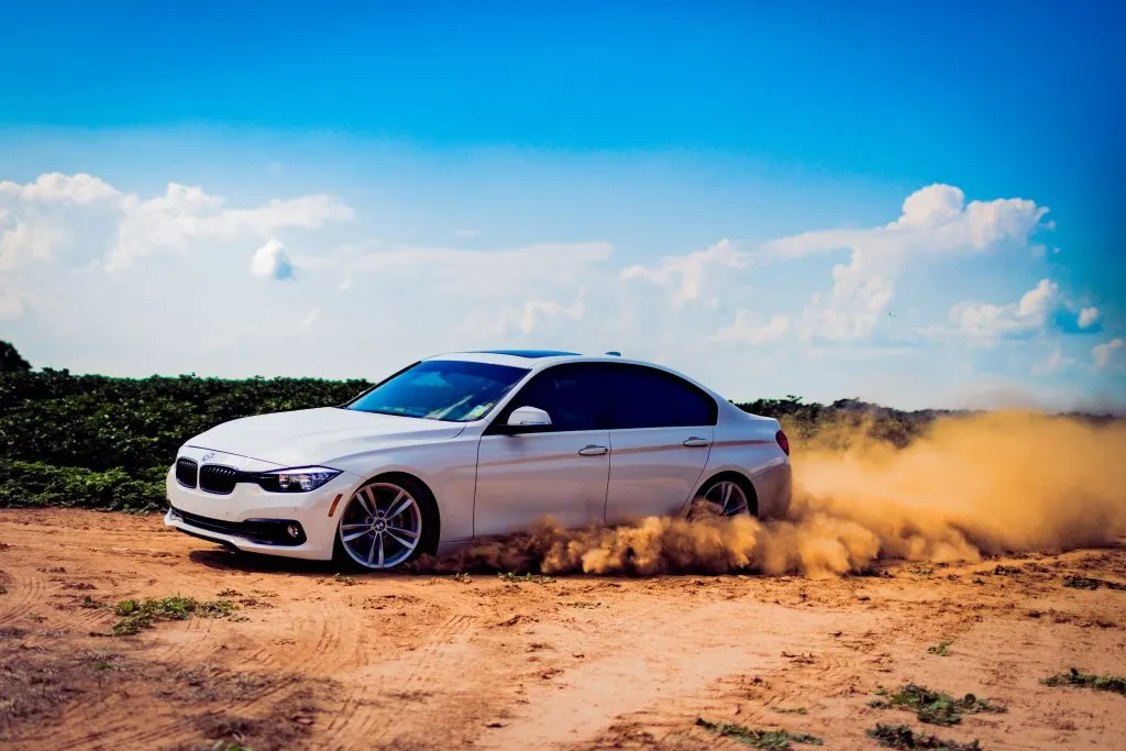 BMW driving on a sandy road