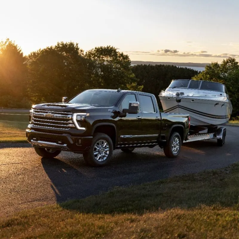 Front 3/4 view of the 2024 Chevrolet Silverado HD High Country towing a boat