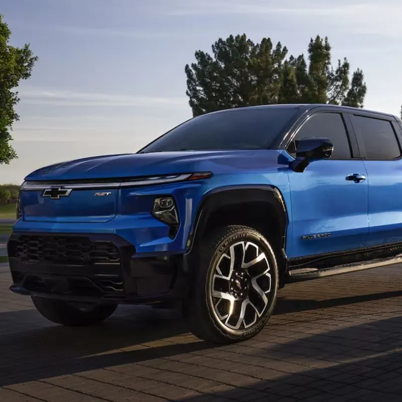 2024 Chevrolet Silverado EV - Blue truck with a cable plugged into a charger
