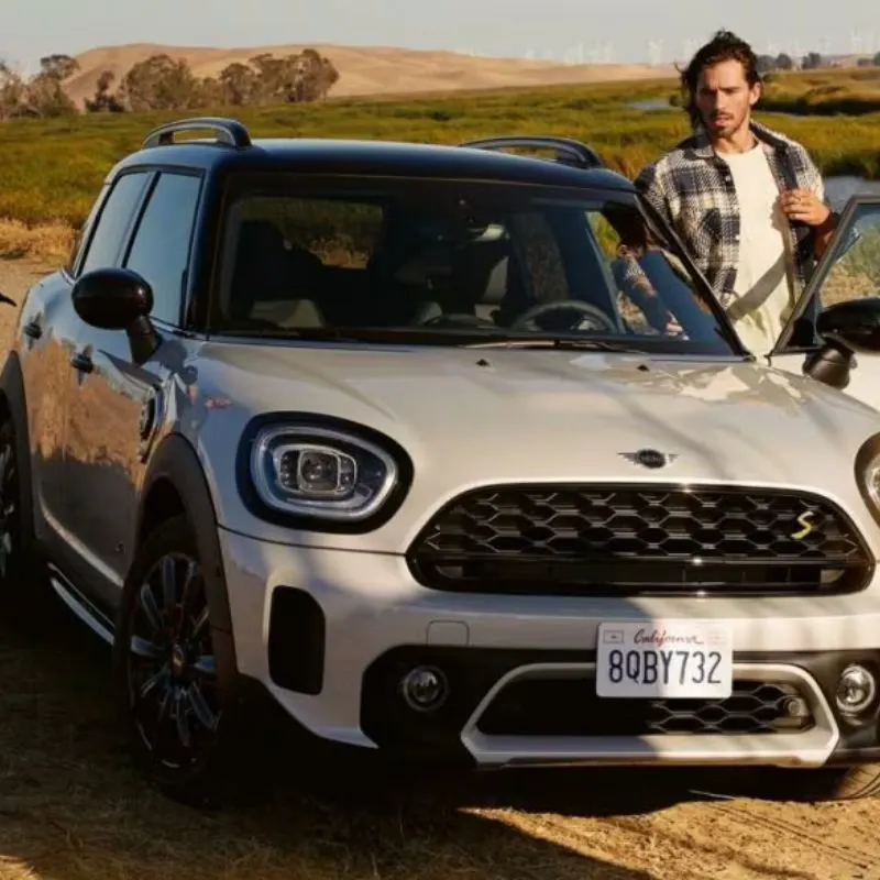 2023 Mini Cooper Electric Hardtop - White EV (front view) and a persong getting in